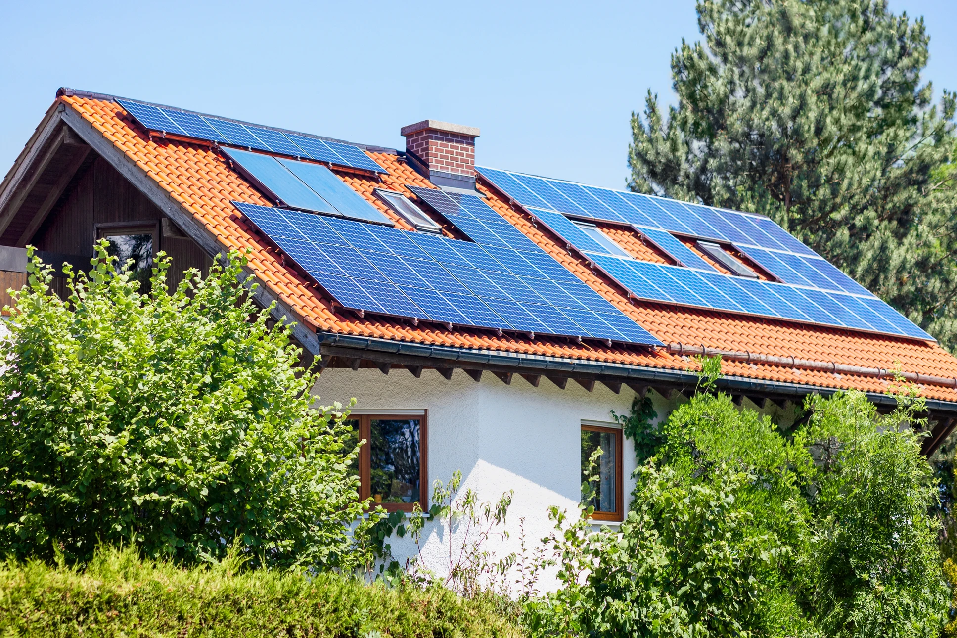 Vue a&eacute;rienne d'un b&acirc;timent commercial &eacute;quip&eacute; de panneaux solaires photovolta&iuml;ques sur toiture bleue ondul&eacute;e, au coucher du soleil