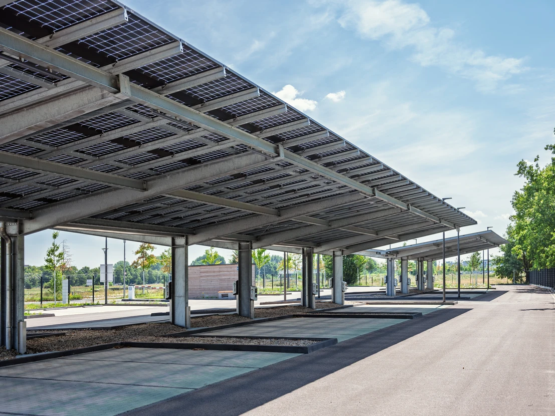 Deux techniciens installent des panneaux solaires photovoltaïques sur une toiture résidentielle par temps ensoleillé