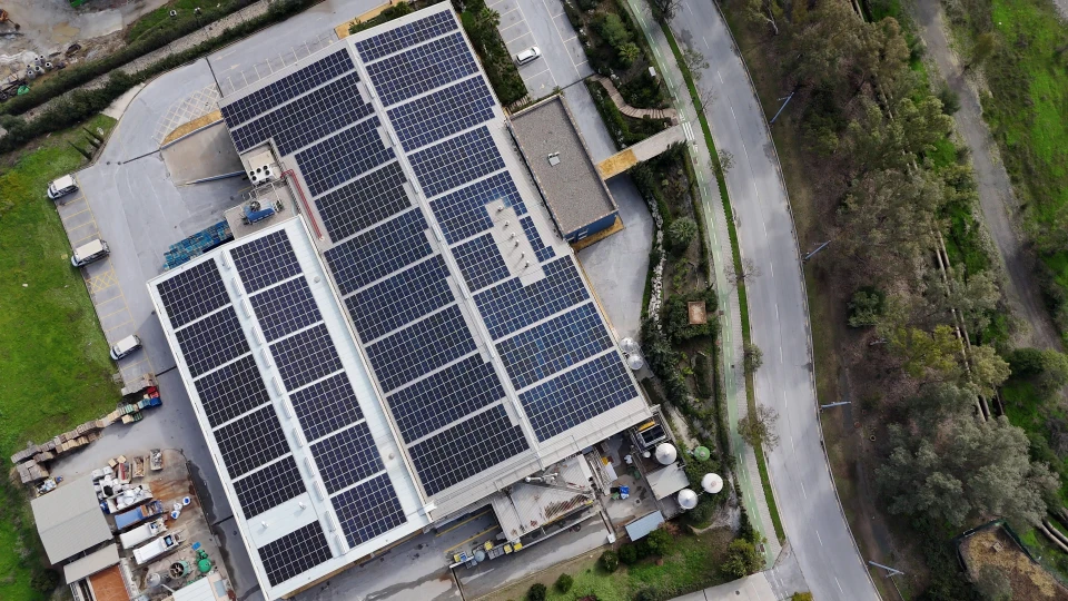 vue sur le toit d'un immeuble avec une cheminée et des panneaux solaires photovoltaïques