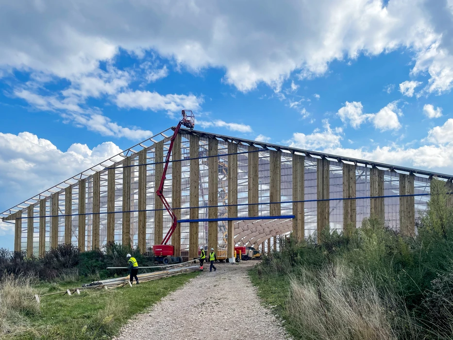 Deux techniciens installent des panneaux solaires photovoltaïques sur une toiture résidentielle par temps ensoleillé