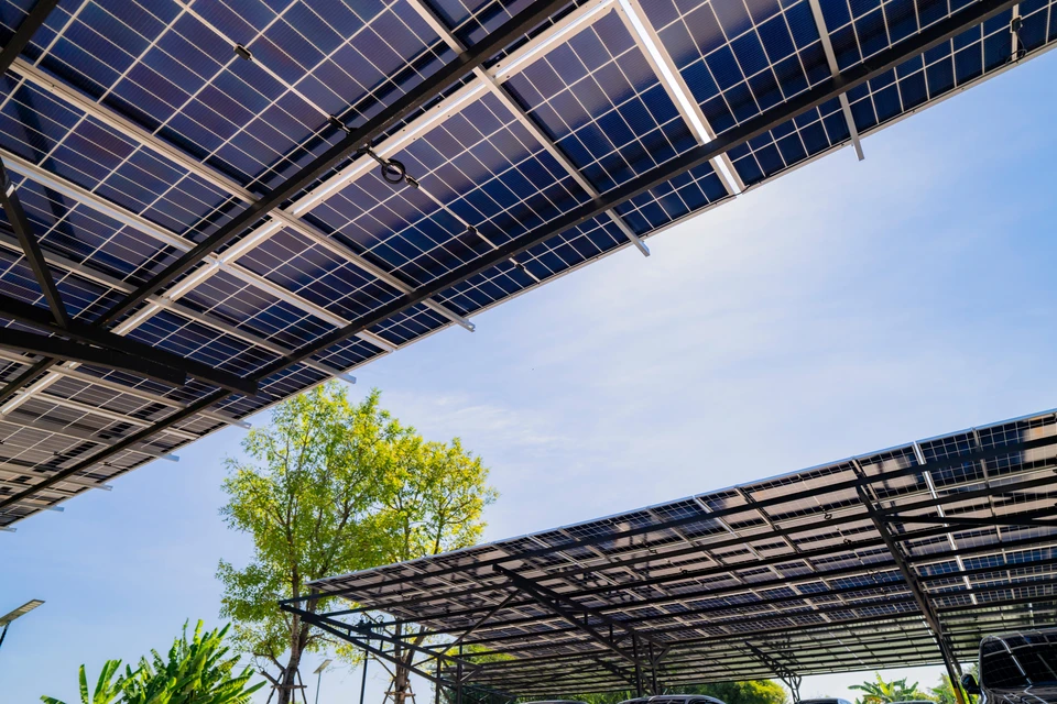 Scène extérieure sur installation solaire avec ouvriers en équipement de sécurité installant des panneaux photovoltaïques