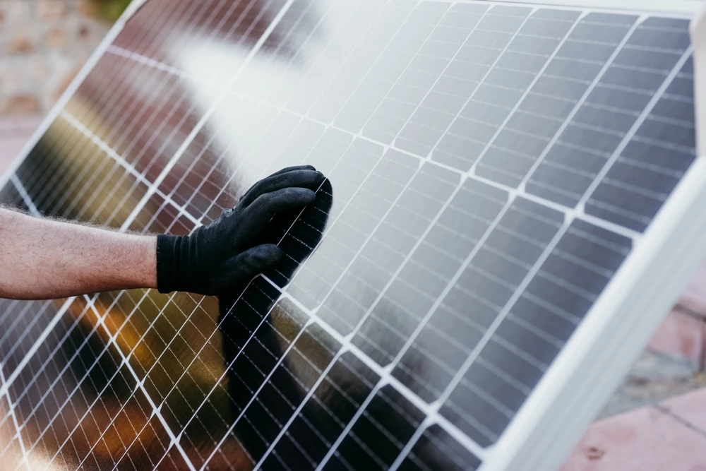 Toiture industrielle couverte de panneaux solaires photovoltaïques monocristallins noirs, vue aérienne en perspective centrale
