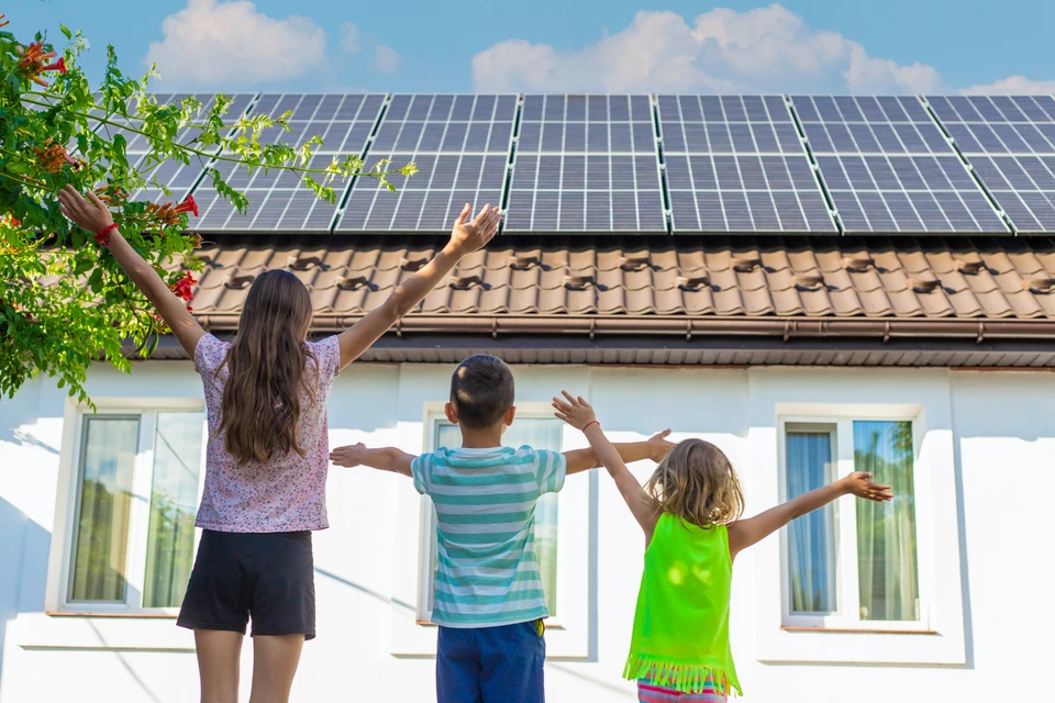 Scène extérieure sur pelouse verte avec personne utilisant ordinateur portable blanc connecté par câble vert à panneau solaire photovoltaïque